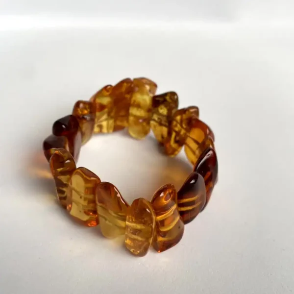 Elegant amber bead bracelet featuring polished beads in rich browns and golden yellows.