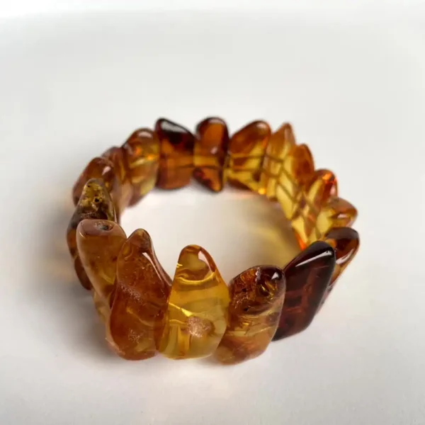 Beautiful amber bracelet with distinct hues and polished pieces on a flexible band.