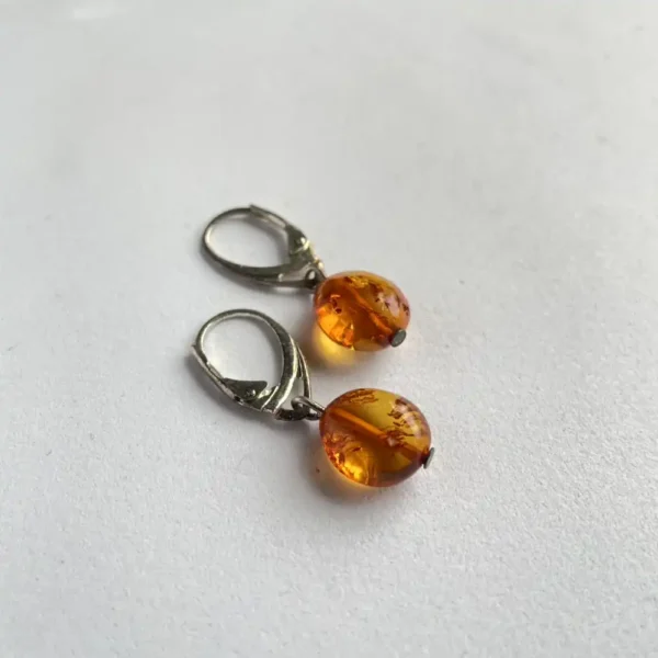 Elegant amber bead earrings with leverback clasps, showcasing natural inclusions and warm hues.