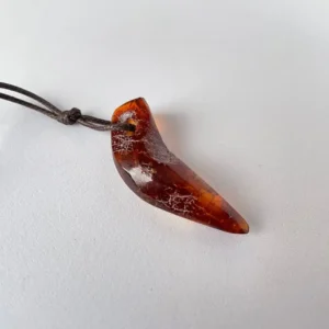 Amber fang pendant on a brown cord, showcasing natural elegance and unique craftsmanship.