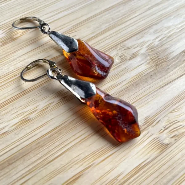 Handcrafted amber earrings featuring elegant metallic hooks and a natural design.