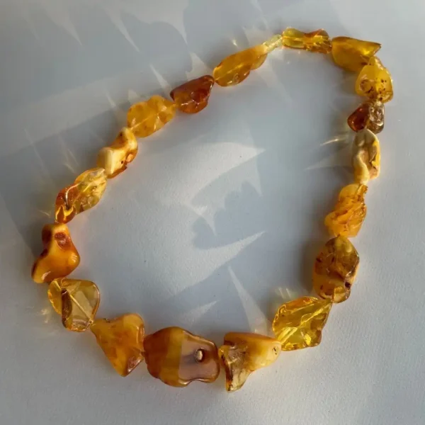 Natural amber necklace with polished irregular beads showcasing radiant golden hues and unique inclusions.