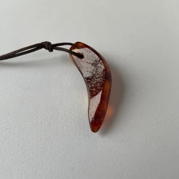 Stunning amber claw pendant on leather cord, showcasing natural warmth and unique handcrafted design.