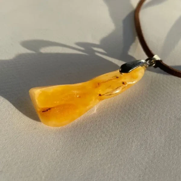 Elegant amber pendant, showcasing natural inclusions and rich golden-yellow hues.