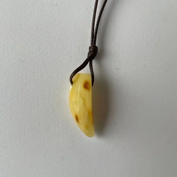 Stylish amber pendant on leather cord, showcasing natural elegance and unique organic design.