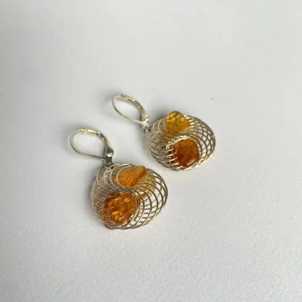 Elegant amber and spiral earrings featuring unique gemstones in artistic metalwork design.