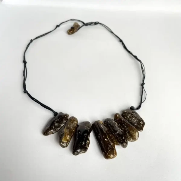 Handmade natural amber stone necklace on black cord, featuring deep brown and amber stones.