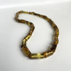 Elegant natural amber necklace with smooth, colorful resin beads on a white background.