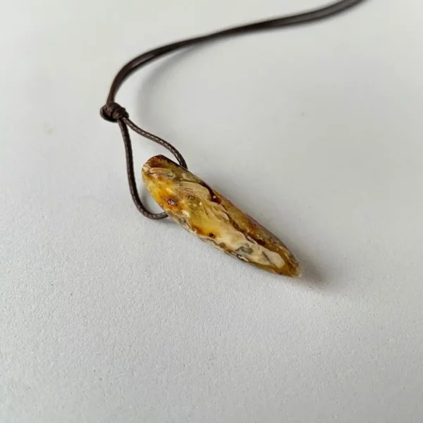 Elegant amber pendant on brown cord, showcasing natural stone beauty and earthy tones.