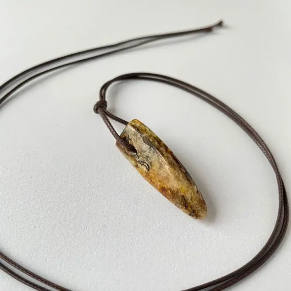 Handcrafted amber natural stone necklace with unique arrowhead pendant and adjustable brown cord.