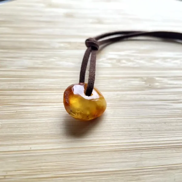 Elegant amber pendant on suede cord, showcasing natural beauty and handcrafted charm.