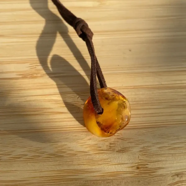 Amber pendant on leather cord, showcasing natural beauty and artisan craftsmanship.