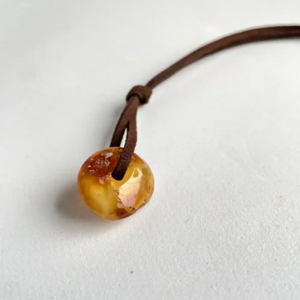 Amber pendant on a leather cord, showcasing natural elegance and rustic charm in jewelry.