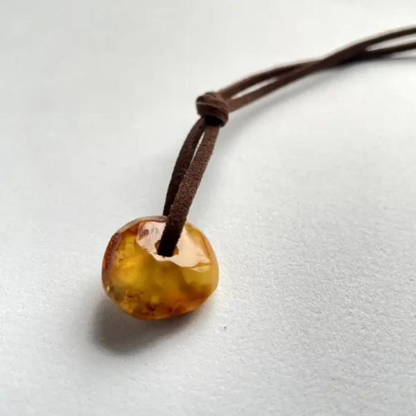 Stunning amber pendant on a suede cord, showcasing natural beauty and timeless elegance.