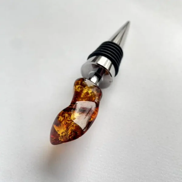 Elegant amber resin wine stopper with metallic tip and rubber seal for preserving wine freshness.