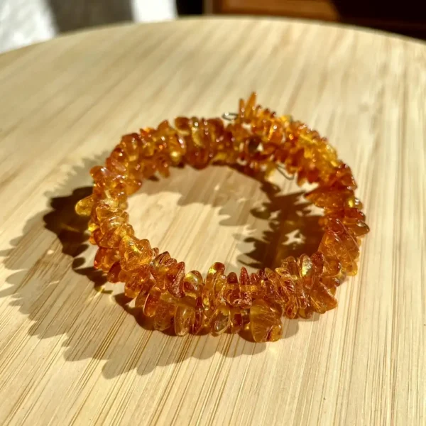 Stunning handcrafted amber bracelet featuring polished stones in warm honey tones on wood.