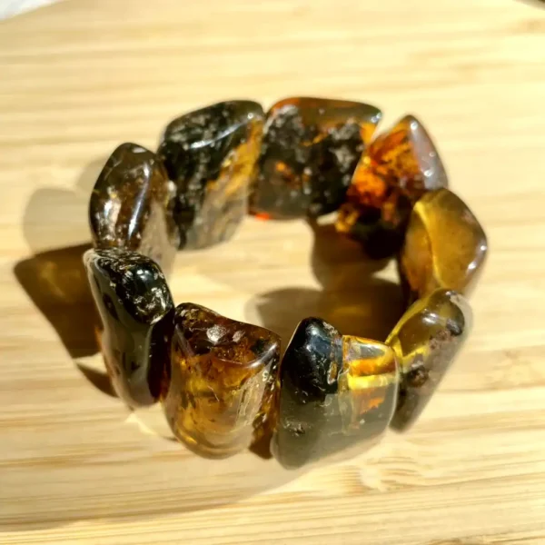 Beautiful amber bracelet featuring unique natural stones on a light wooden surface.