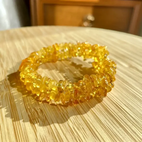 Beautiful amber bracelet on a light wooden surface showcasing natural unique beads and warm colors.