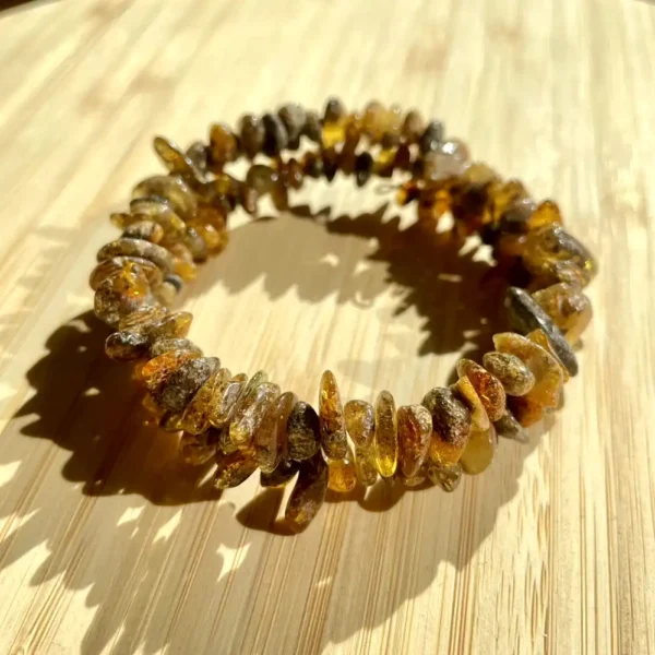 Beautiful amber bracelet with polished beads on a textured bamboo surface.