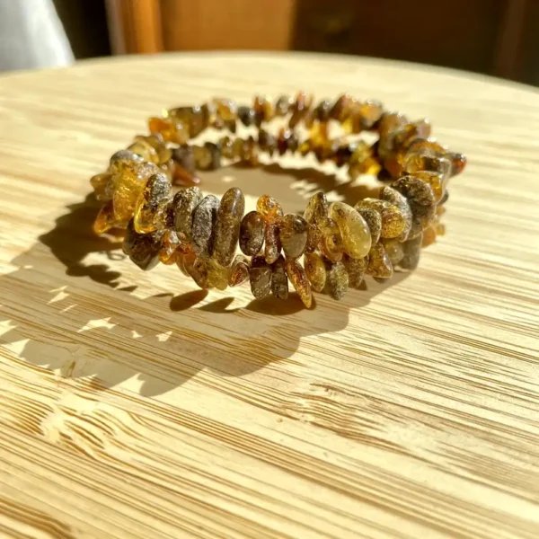 Handmade amber bracelet with polished beads on a wooden background, perfect for nature-inspired jewelry.