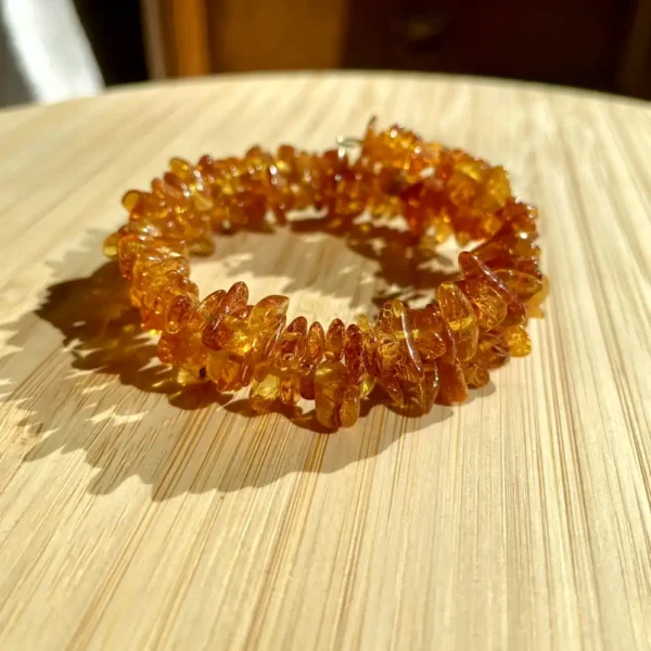 Elegant amber bracelet on a wooden surface, showcasing natural beauty and handcrafted artistry.