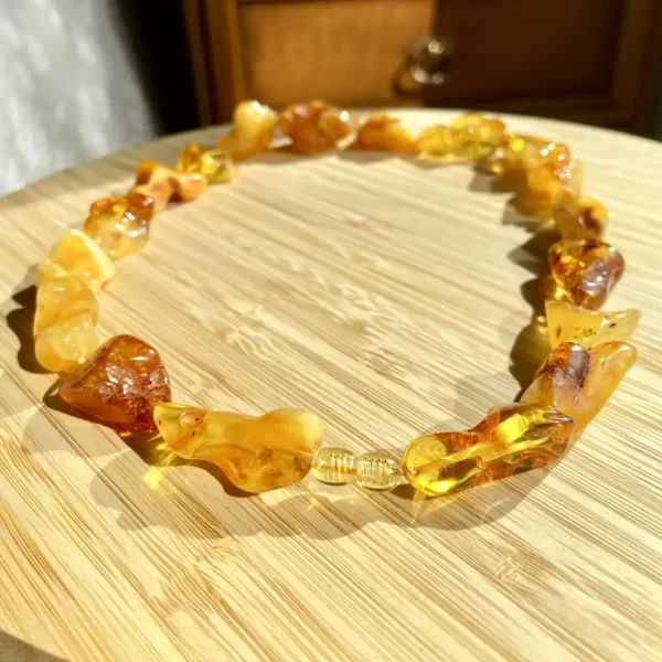 Beautiful amber necklace showcasing vibrant colors and unique shapes on a natural wood surface.
