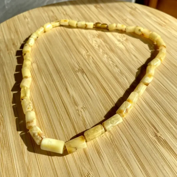 Beautiful amber necklace beads showcasing natural warmth and unique craftsmanship on a wooden surface.