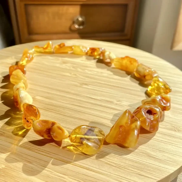 Elegant amber necklace on wooden surface, showcasing warm hues and natural beauty under sunlight.