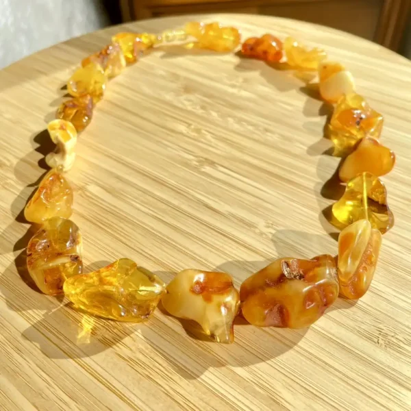 Elegant amber bead necklace showcasing unique colors and natural beauty on a wooden surface.