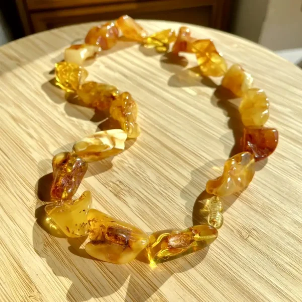 Elegant amber necklace on a wooden surface, showcasing natural beauty and artisanal craftsmanship.