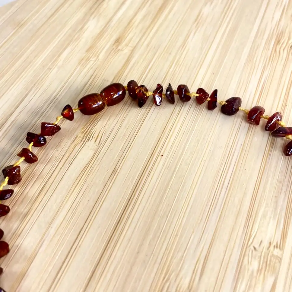 Stunning amber bead arrangement on wood, showcasing diverse shapes and rich, warm hues.