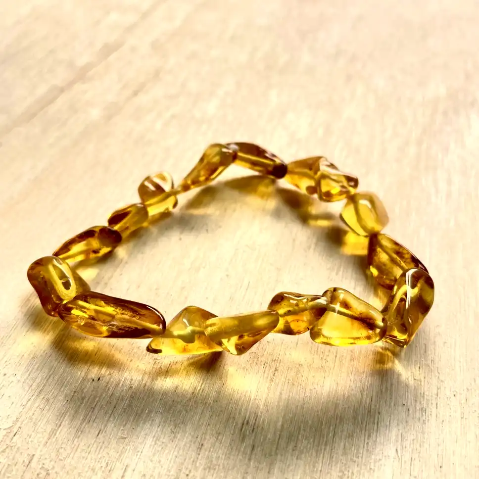 Elegant amber nugget bracelet showcasing polished stones with natural variations and warm golden hues.