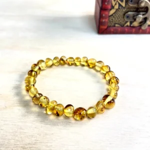 Elegant Amber Bead Bracelet with varied beads displayed atop a beautifully crafted wooden chest.