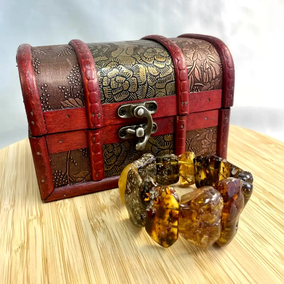 Amber bracelet and ornate jewelry box create a charming treasure display.