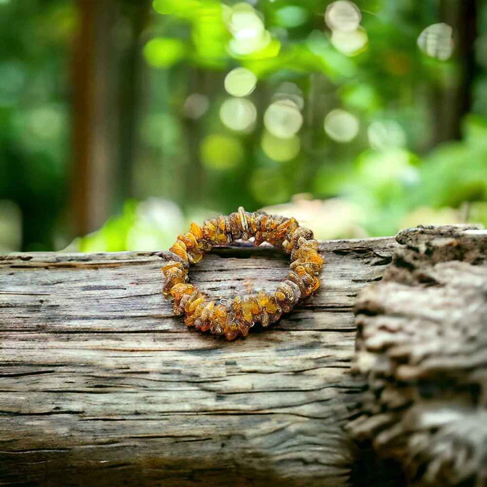 Beautiful amber bracelet on a rustic log, showcasing natural textures and organic elegance.