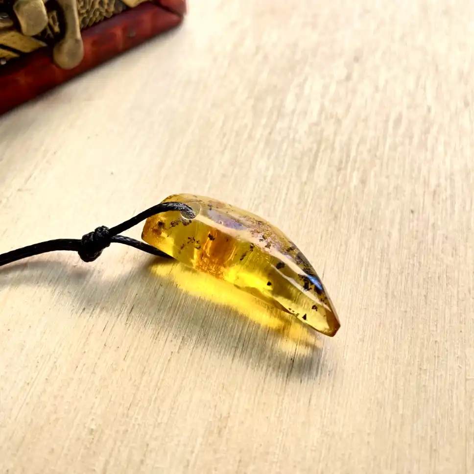 Stunning Amber Pendant Necklace on a black cord, showcasing ancient organic patterns and warm hues.