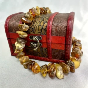 Vintage decorative chest adorned with amber gemstones, showcasing intricate leaf designs and rich hues.