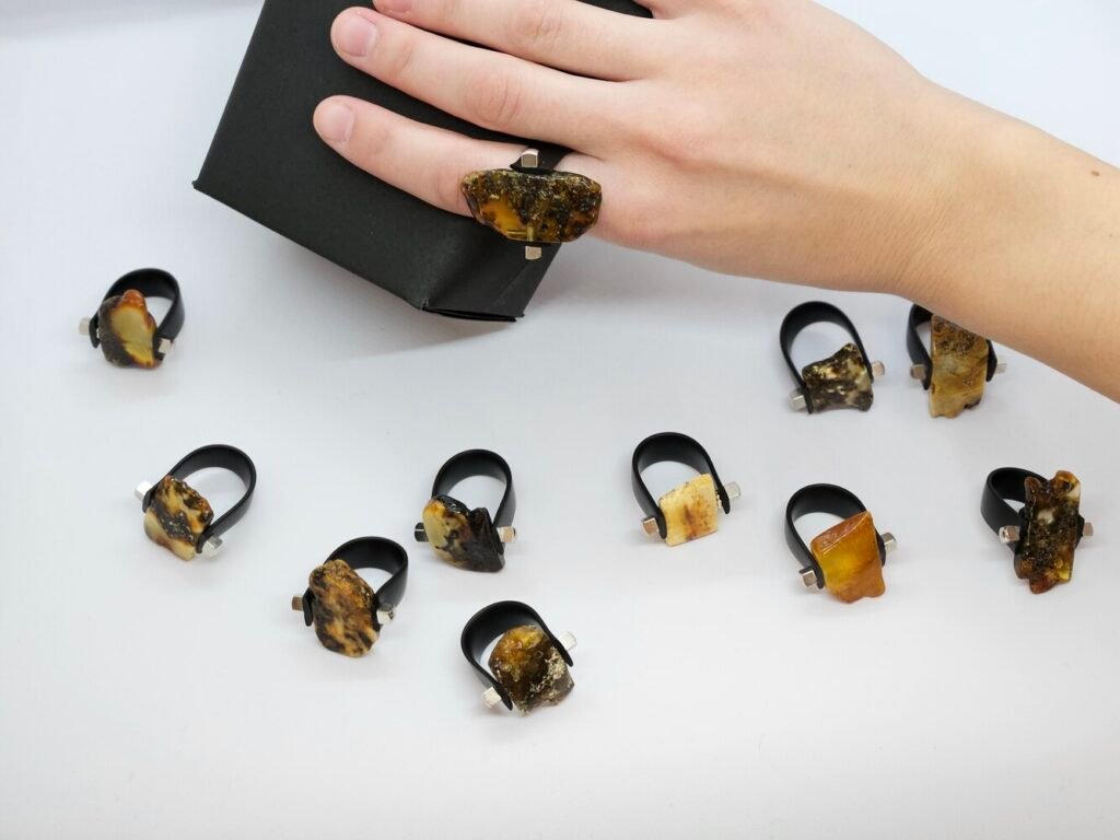 Unique rings featuring natural amber stones in a sleek black box for a stunning presentation.
