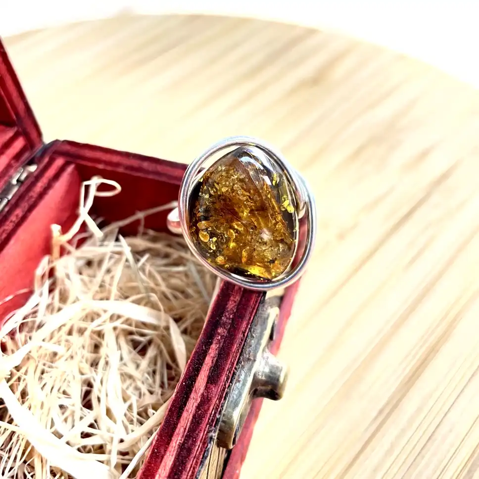 Stunning silver-plated amber gemstone ring in silver setting, elegantly displayed in a luxurious jewelry box.