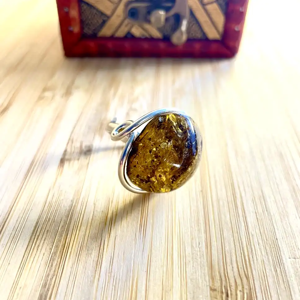 Elegant silver-plated amber ring in silver plating, showcasing organic patterns and warm hues.
