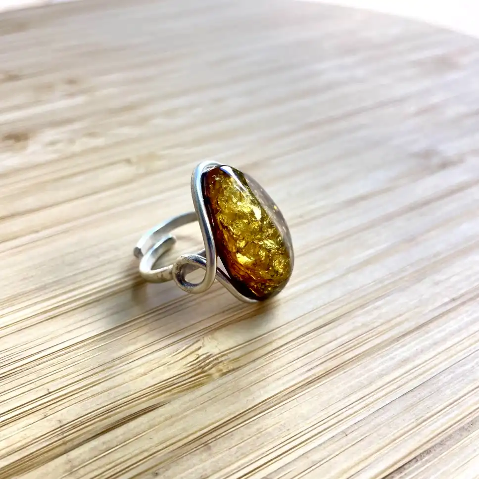 Stunning amber ring with intricately designed silver band, showcasing natural beauty and craftsmanship.