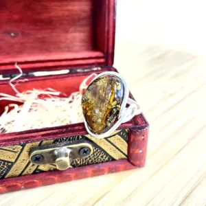 Stunning silver-plated amber ring in silver setting displayed in an ornate red box with golden accents.