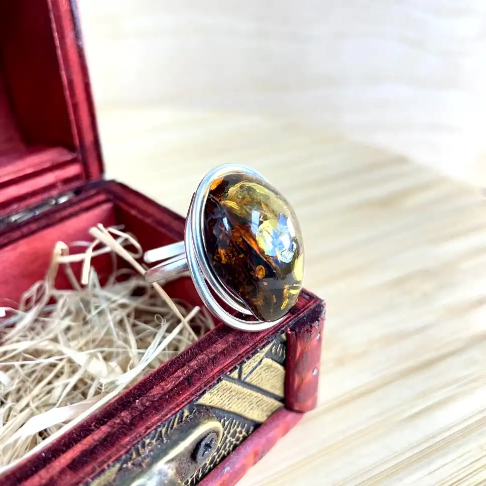 Elegant silver-plated amber ring in silver setting, crafted with vintage charm inside a luxurious jewelry box.