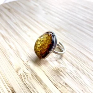 Elegant amber ring with a polished golden stone set in sleek silver, perfect for any occasion.