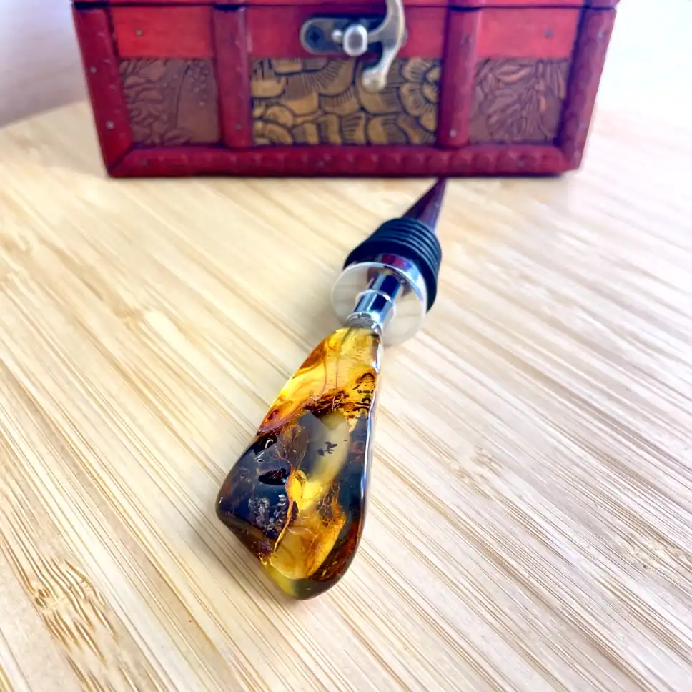 Elegant amber bottle stopper with resin design on wooden surface, paired with decorative box.