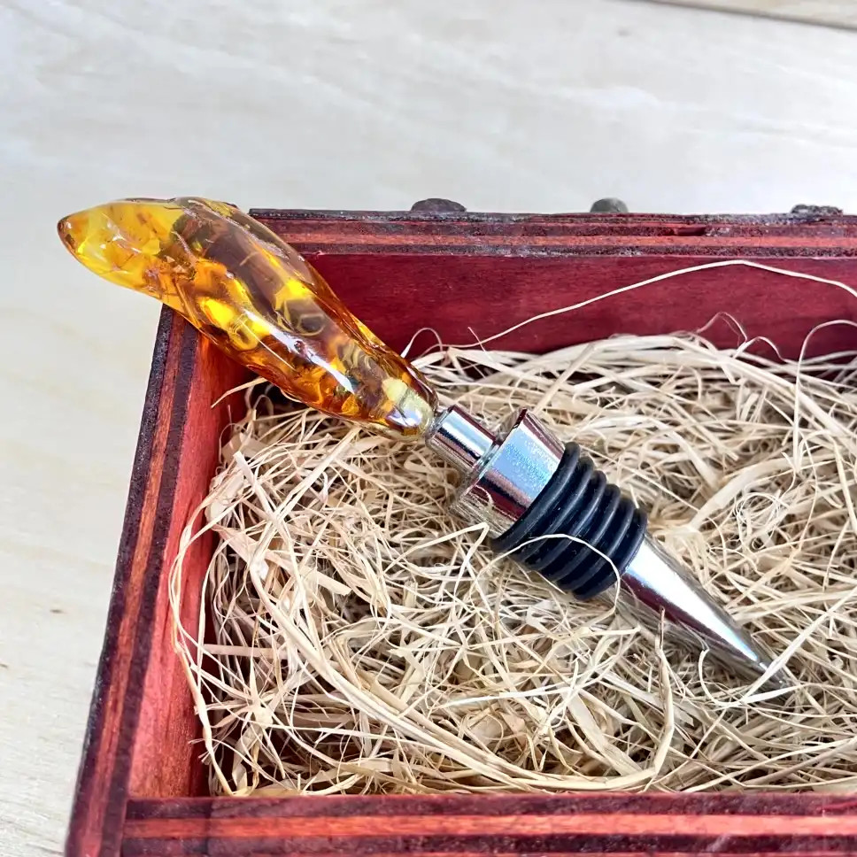 Elegant amber bottle stopper in rustic wooden box, perfect for wine enthusiasts and collectors.