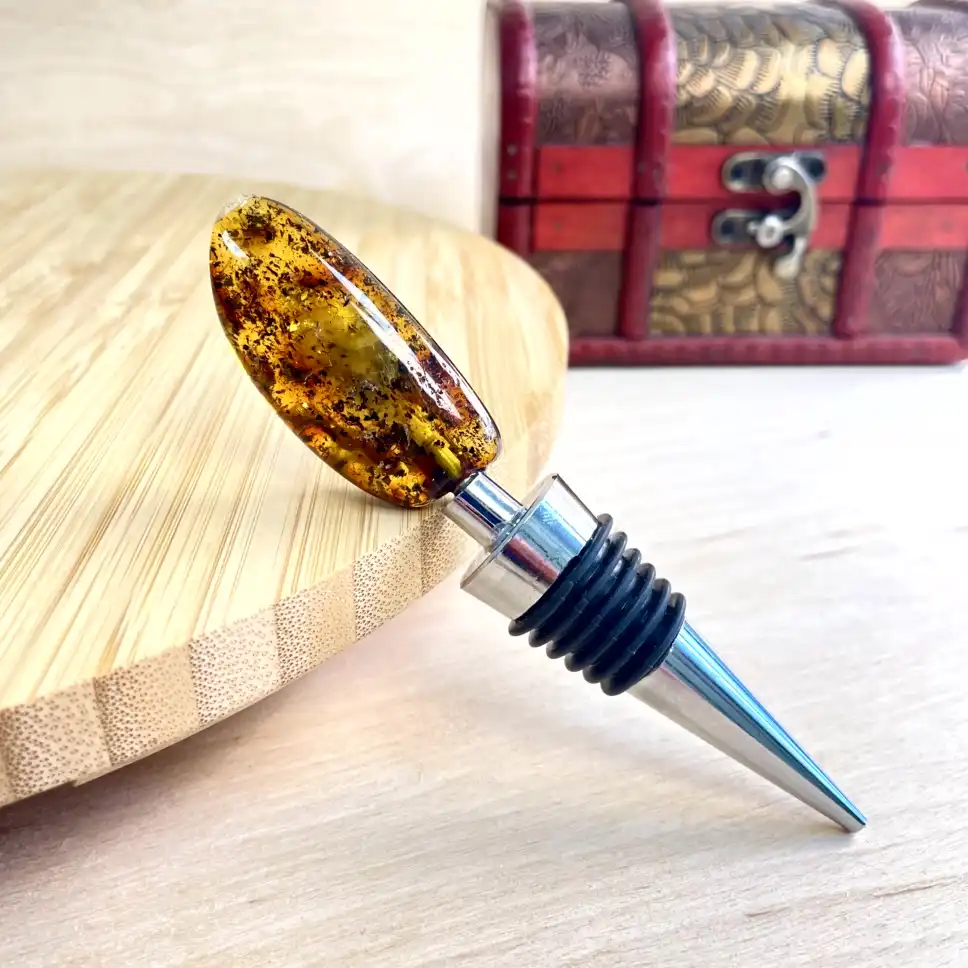 Elegant amber bottle stopper design with polished metal and rubber rings for a perfect seal.