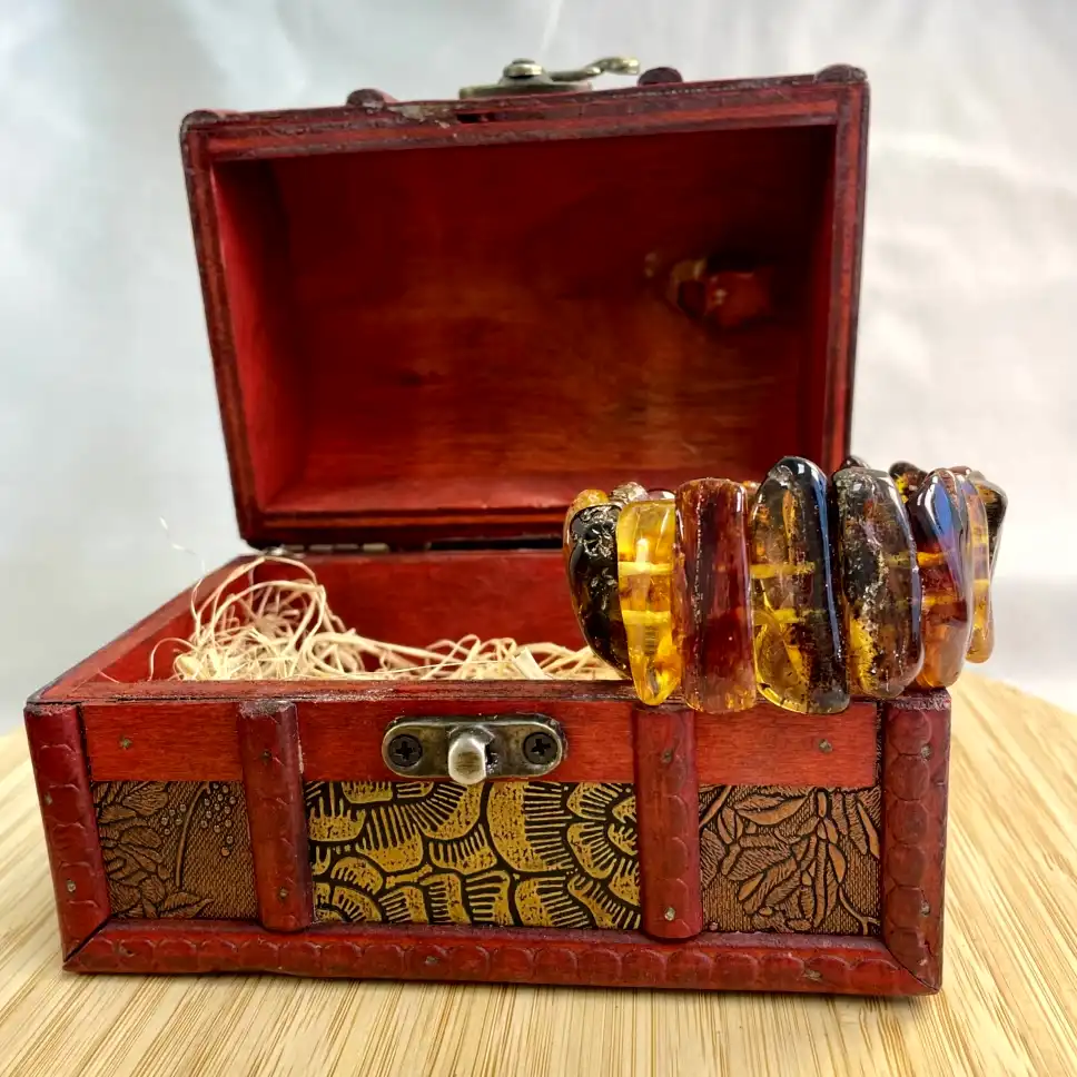 Antique jewelry box with a stunning amber bracelet, showcasing rich colors and intricate craftsmanship.