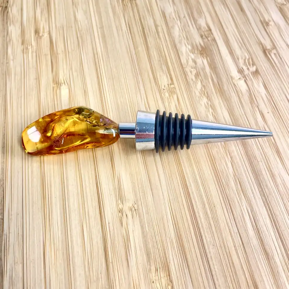 Elegant amber bottle stopper with silver-plated design, perfect for wine lovers and dining decor.