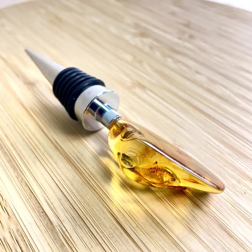 Elegant amber bottle stopper with a sleek metal collar and textured silicone ring.